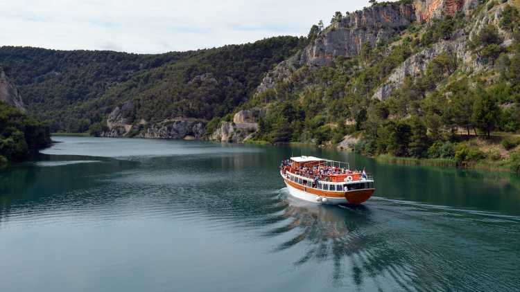 Ausflugsboot auf einem See umgeben von Felslandschaft