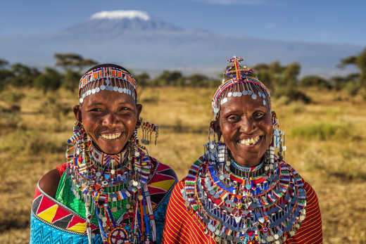 Afrikanische Frauen vom Stamm der Massai mit dem Kilimandscharo im Hintergrund.