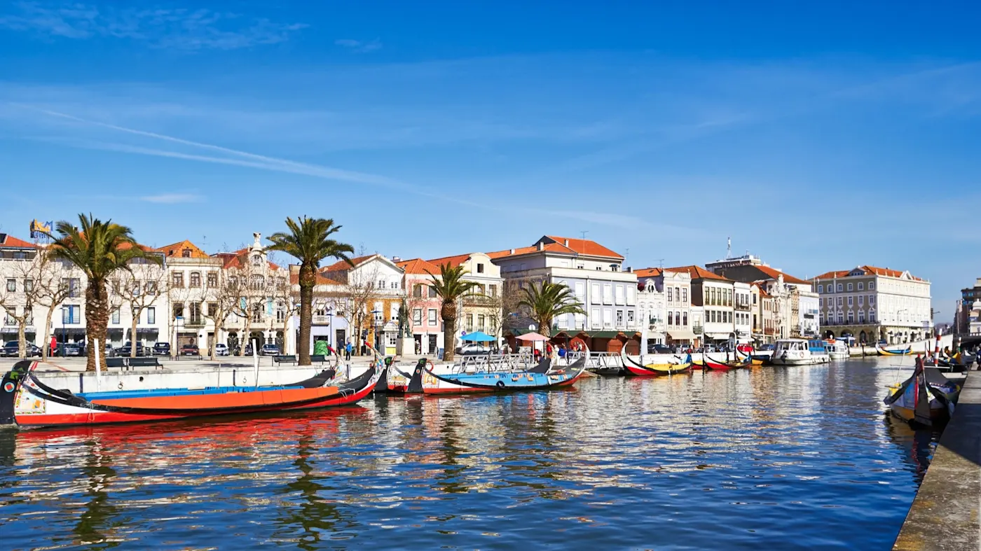 Aveiro, Portugal Bunte Boote am Kanal mit Palmengärten und historischen Gebäuden in Aveiro, Portugal.