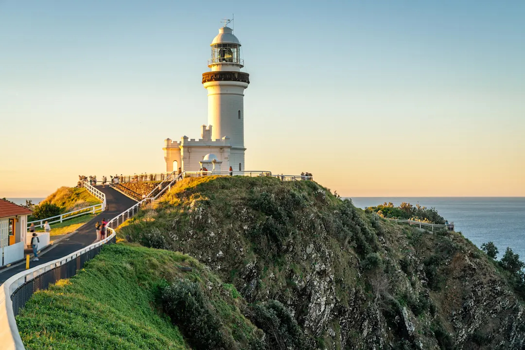 Majestätischer Leuchtturm auf einer Klippe bei Sonnenuntergang mit Blick auf das Meer. Byron Bay, New South Wales, Australien.