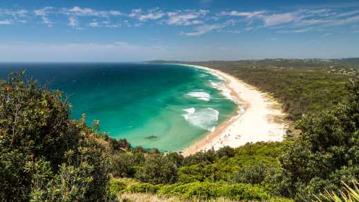 Luchtfoto van het populaire Byron Bay strand, ideaal voor een surfstop tijdens uw road trip in Australië.