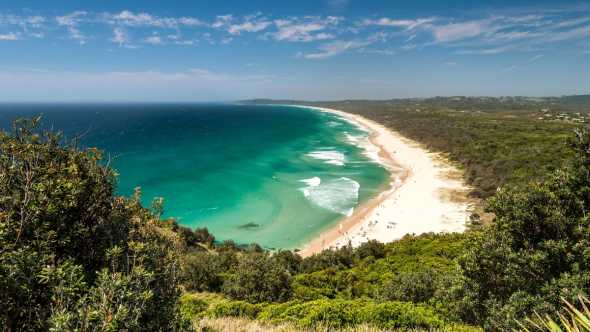 Vue aérienne sur la très populaire plage de Byron Bay, idéale pour une étape surf pendant votre road trip en Australie.