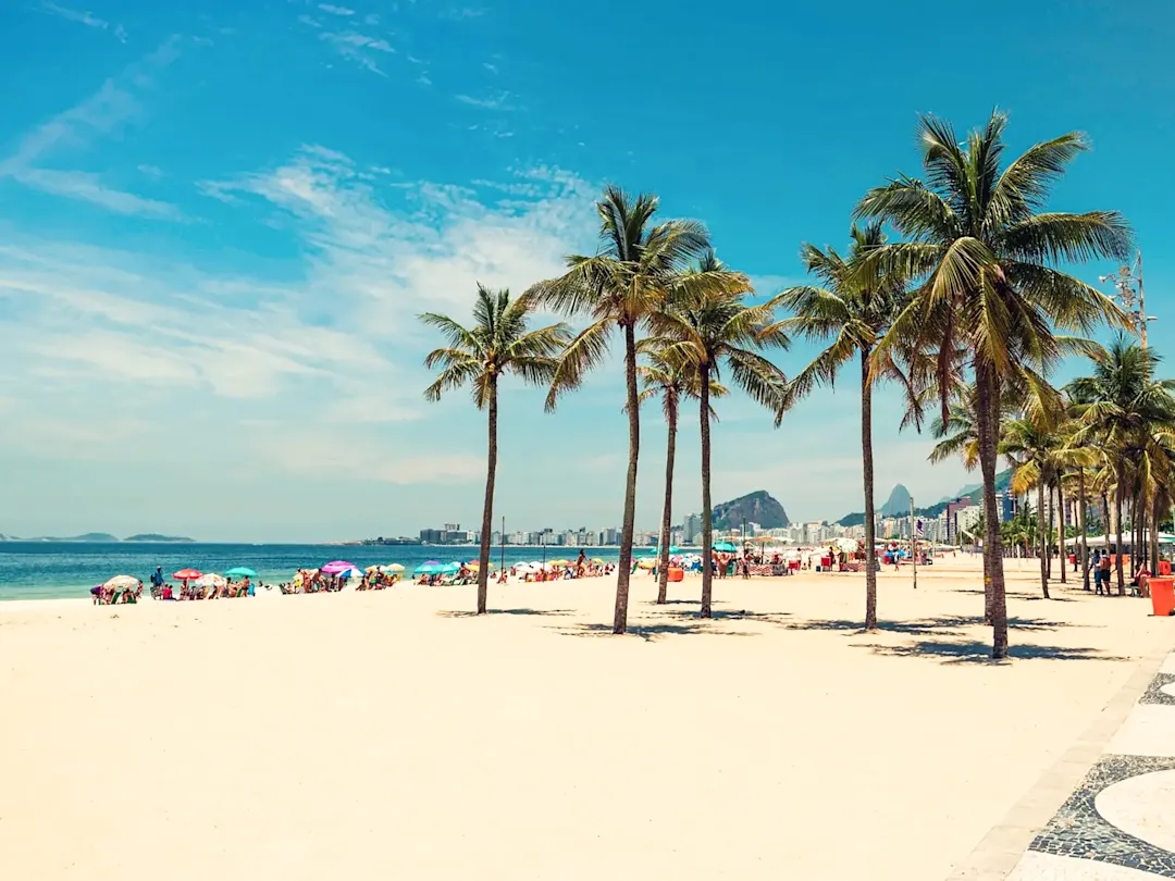Brasilien, Rio de Janeiro, Rio de Janeiro Copacabana-Strand mit Palmen und Sonnenschirmen. Rio de Janeiro, Rio de Janeiro, Brasilien.
