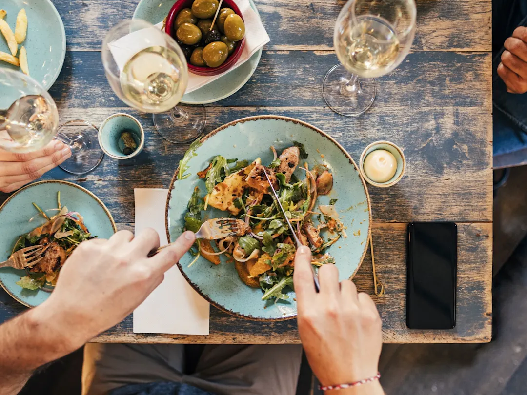 Ansicht eines rustikalen Mittagstisches mit Salat, Oliven und Wein. Perth, Western Australia, Australien.