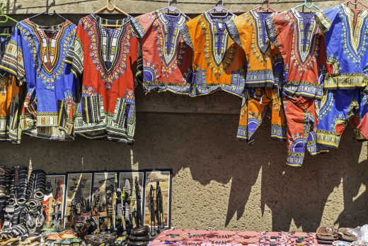 Afrikanische Kuriositäten und Kleidung an der Wand.