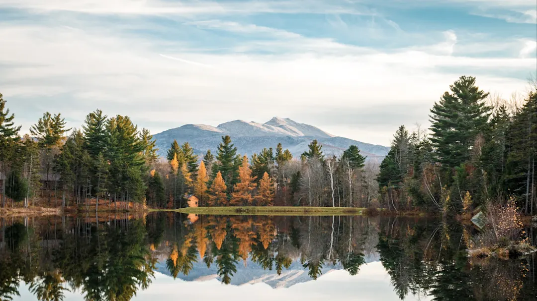 Spiegelnder See mit herbstlichen Bäumen und Blick auf den Mount Mansfield. Vermont, Neuengland, USA.