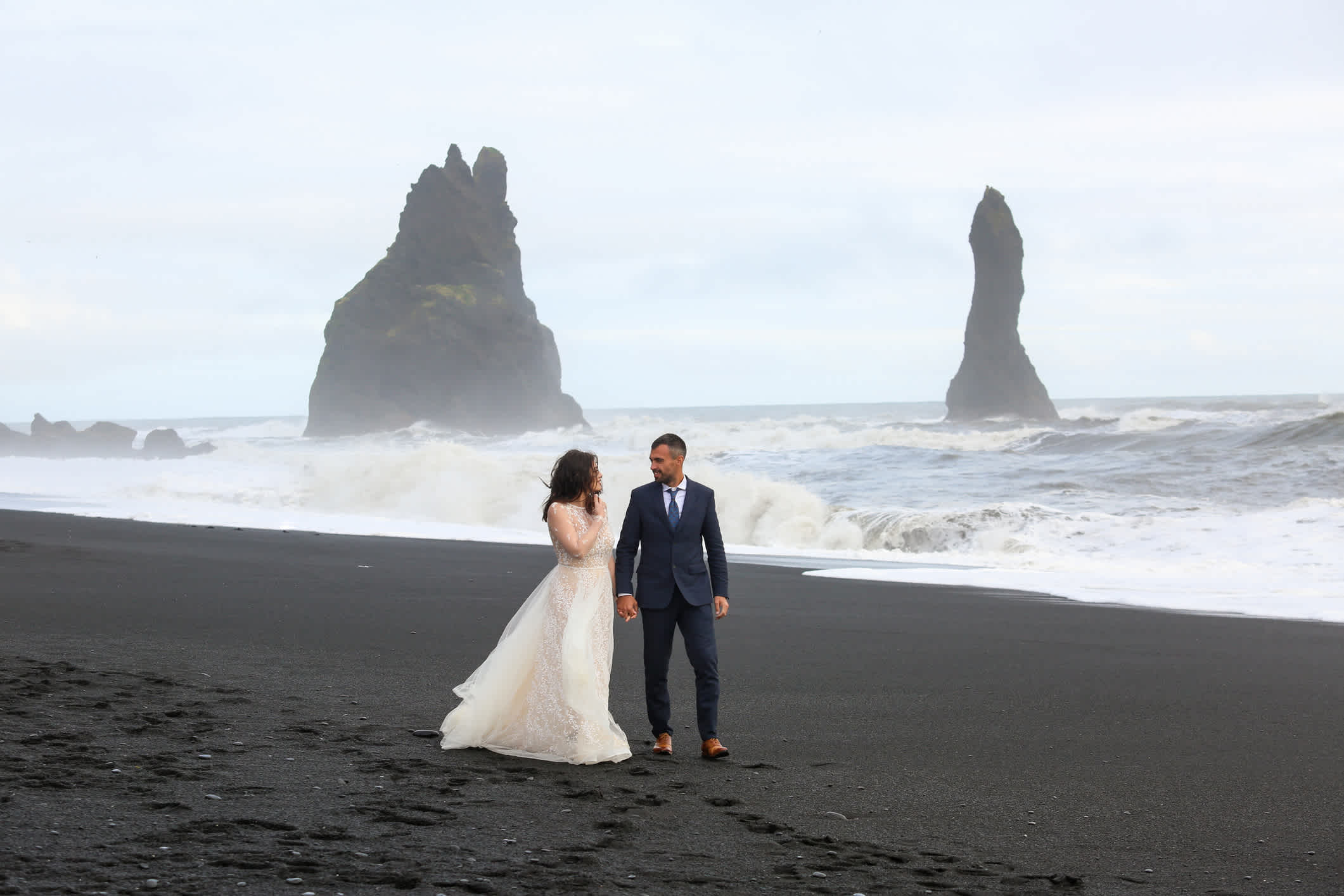 Schönes Hochzeitspaar posiert am Strand Reynisfjara, Island. 