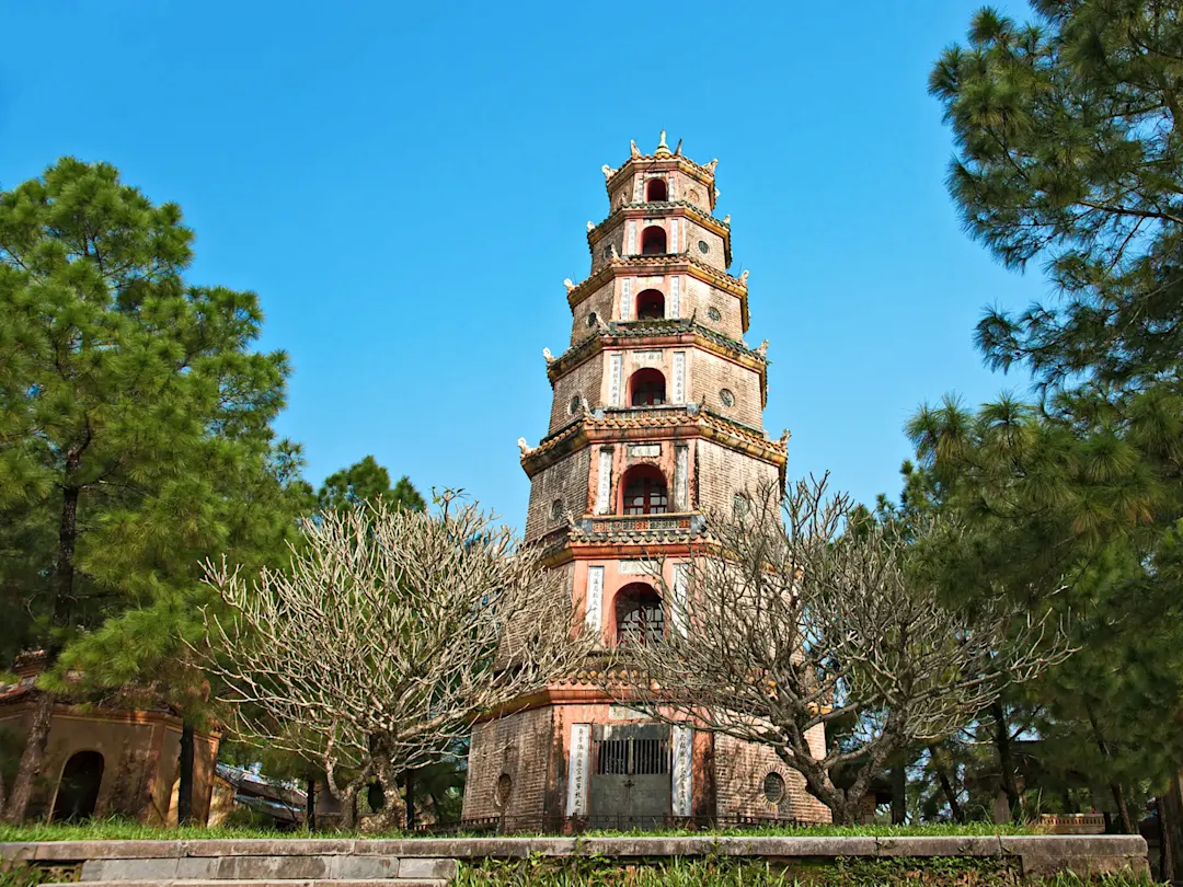 Siebenstöckige buddhistische Pagode mit Bäumen. Thien Mu Pagode, Thua Thien Hue, Vietnam.