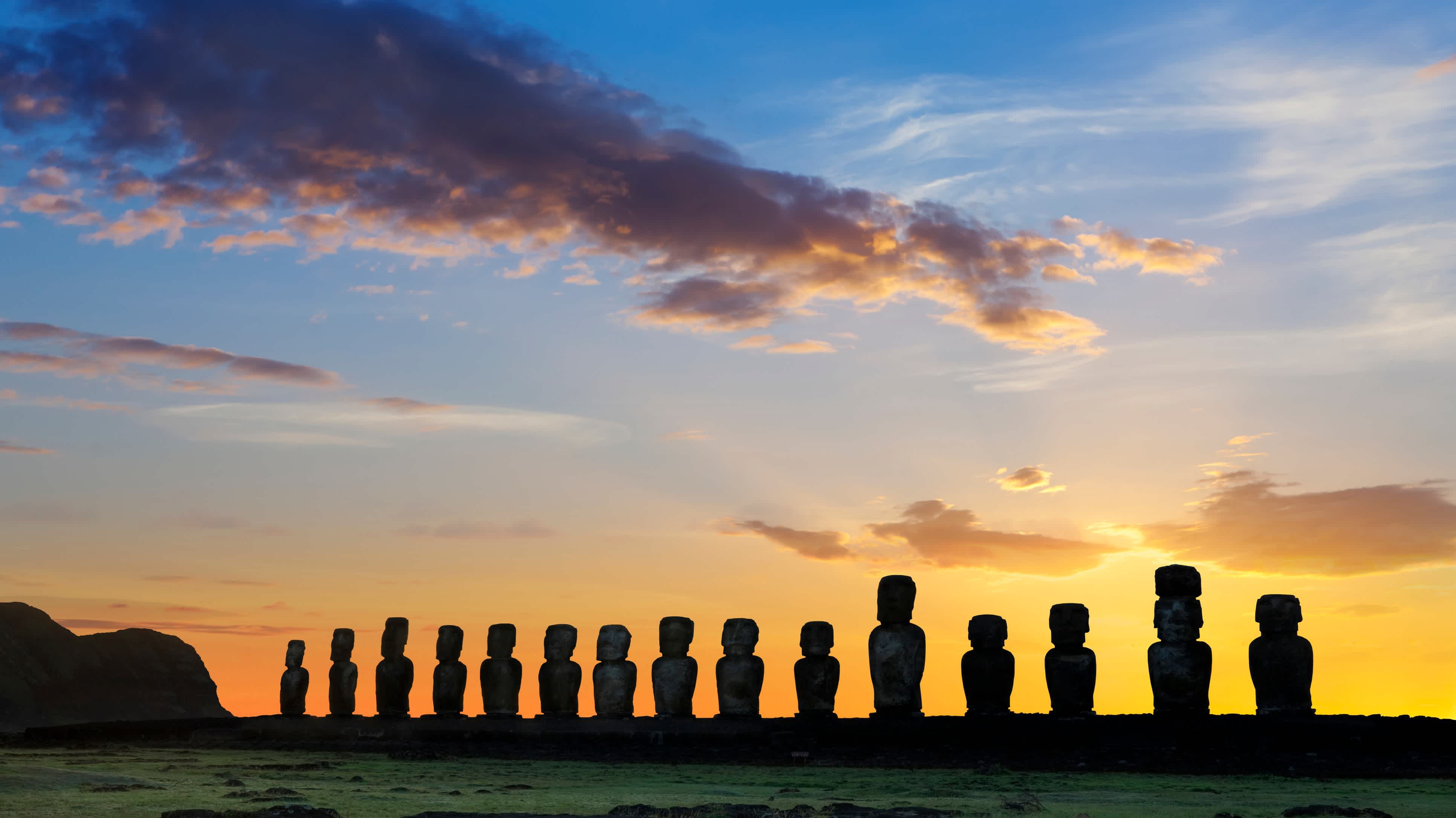 Magnifique panorama sur les statues millénaires de l'Île de Pâques au coucher du soleil, étape incontournable pour tous les voyageurs en voyage au Chili.