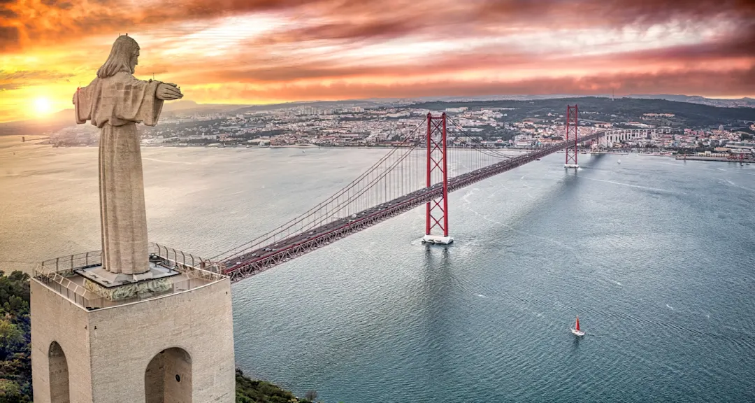 Cristo-Rei-Statue und 25. April-Brücke bei Sonnenuntergang, Almada, Region Lisboa, Portugal