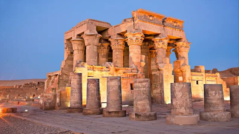 Kom Ombo, Assuan, Ägypten Der beleuchtete Doppeltempel von Kom Ombo mit markanten Säulen und Reliefs am Nilufer bei Abenddämmerung, in Kom Ombo, Assuan, Ägypten.