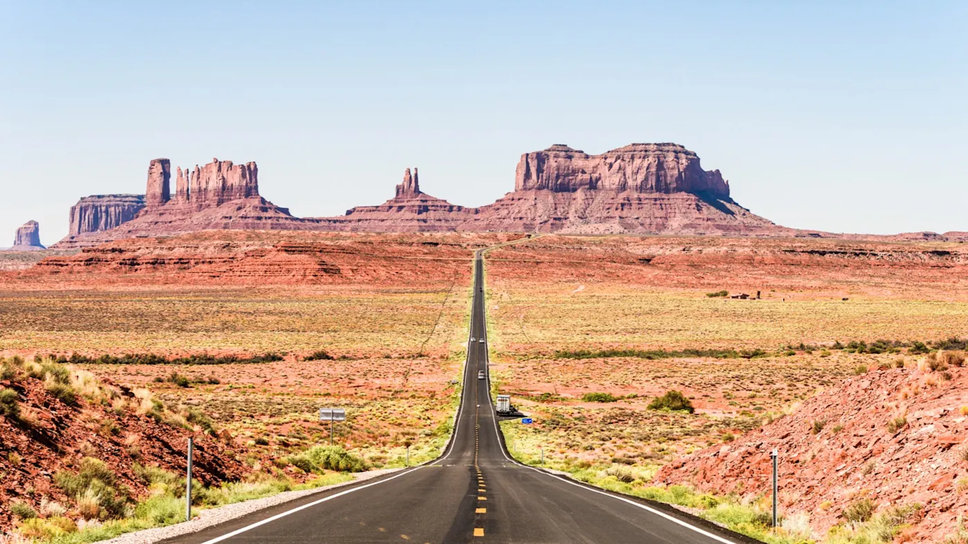 Route 66, Arizona, Monument Valley, Vereinigte Staaten Endlose Straße führt ins Monument Valley, umgeben von ikonischen Felsformationen. Monument Valley, Arizona, Vereinigte Staaten.