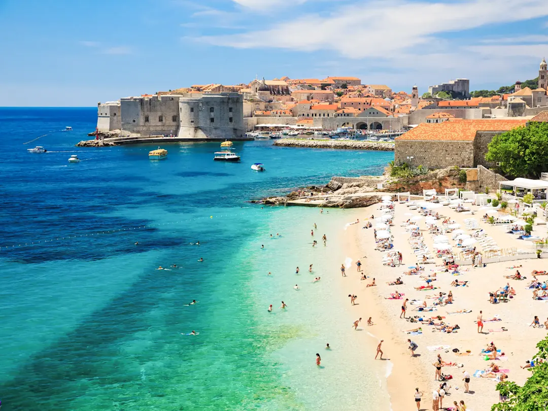 Sandstrand mit Blick auf die Altstadt und das Meer. Dubrovnik, Kroatien.