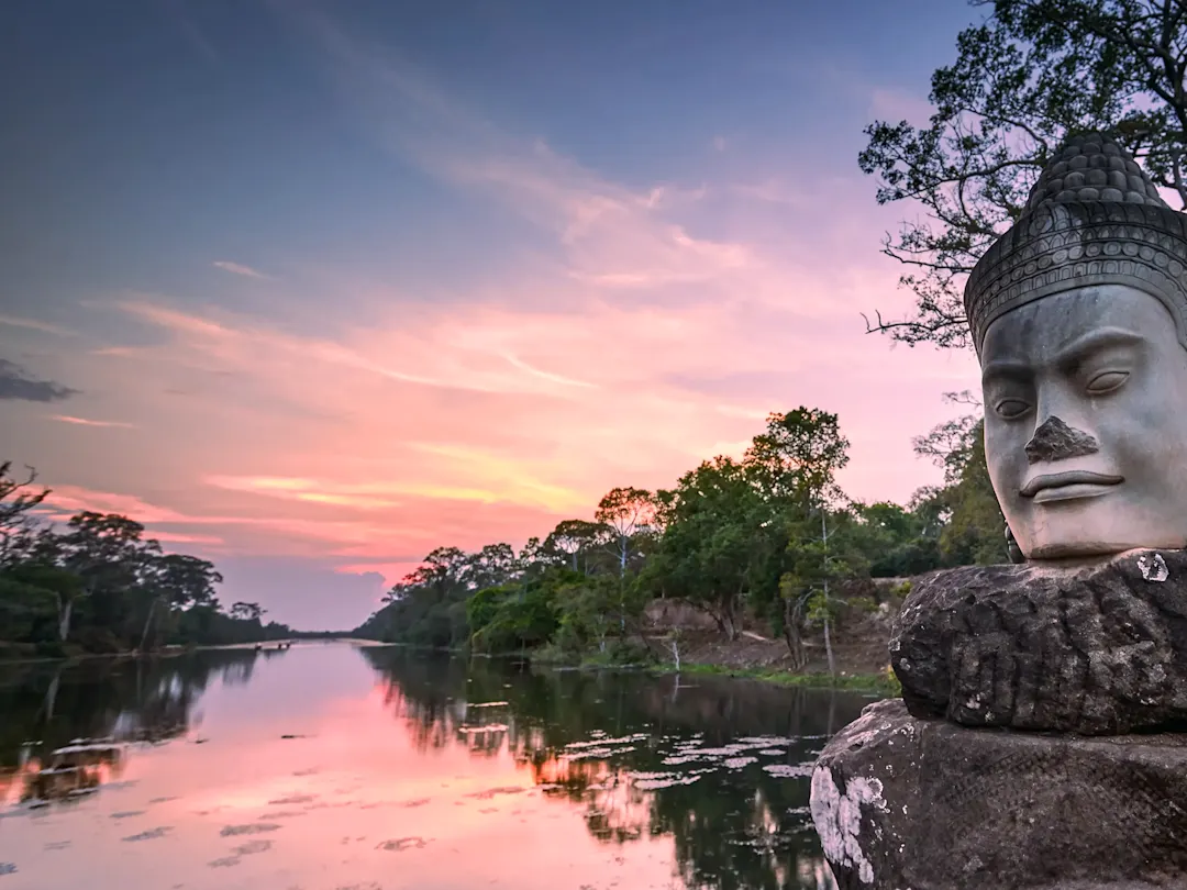 Steinstatue am Flussufer bei Sonnenuntergang. Angkor Thom, Siem Reap, Kambodscha.