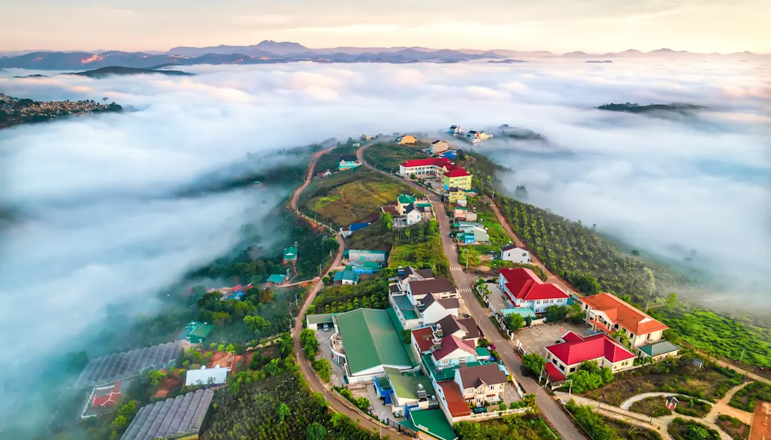 Häuser über den Wolken inmitten einer Berglandschaft bei Dalat in Vietnam.