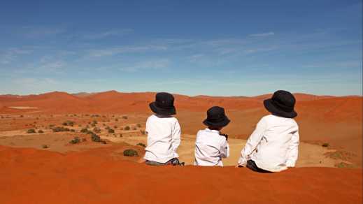 Kinder auf roten Sanddünen in Sossusvlei, Namibia.