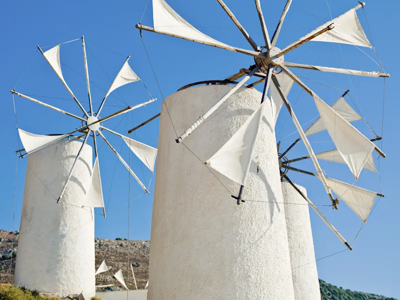 Zwei Windmühlen mit weißen Flügeln vor blauem Himmel. Heraklion, Kreta, Griechenland.
