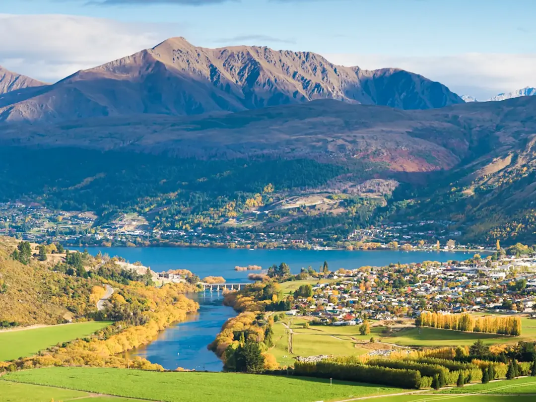 Stadt am See mit Bergen im Herbst. Queenstown, Otago, Neuseeland.
