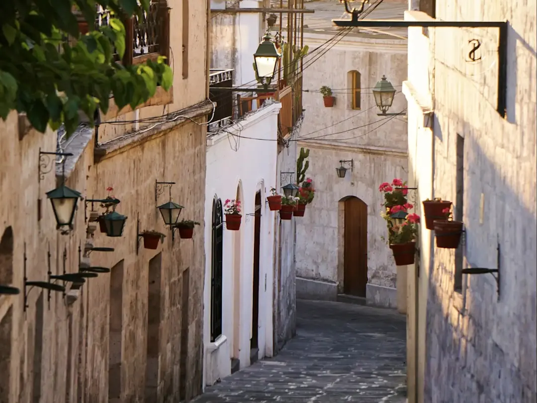 Schmale Gasse mit weißen Kolonialgebäuden und Blumen. Stone Town, Sansibar, Tansania.