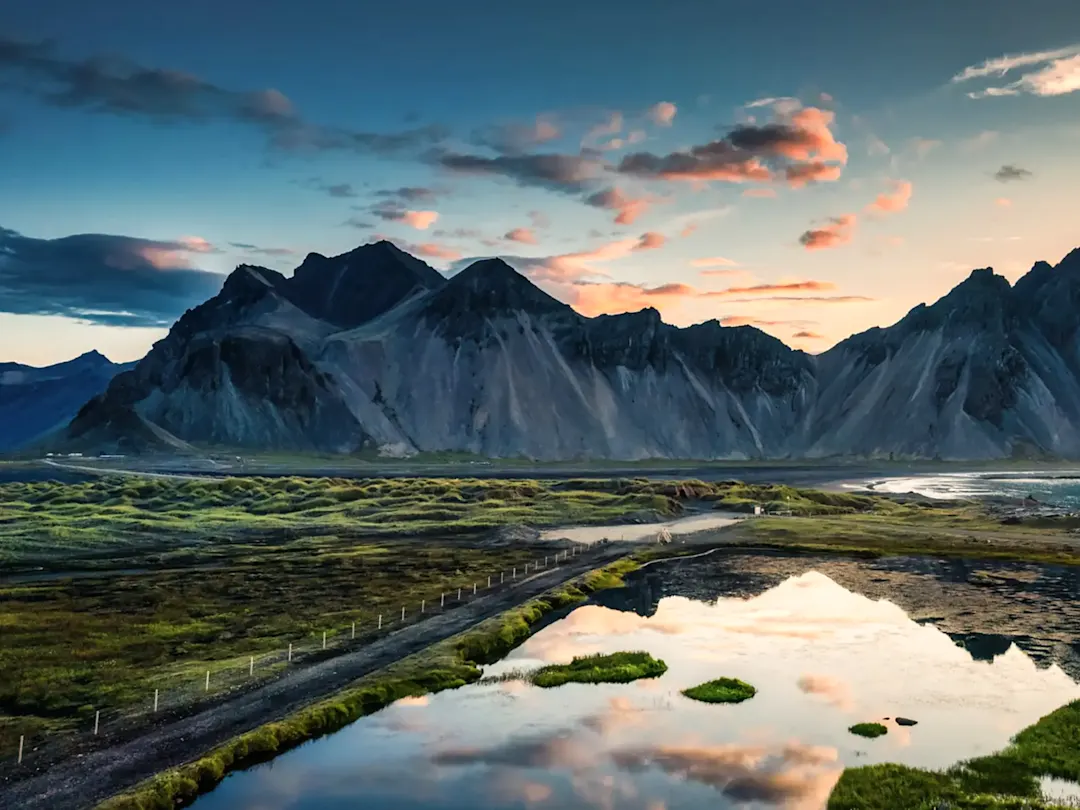Dramatische Berglandschaft mit Sanddünen und Spiegelung im Wasser. Vestrahorn, Austurland, Island.