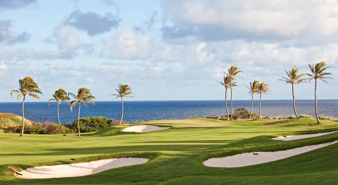 Golfplatz mit grünem Rasen und tropischer Vegetation am Meer. Mauritius