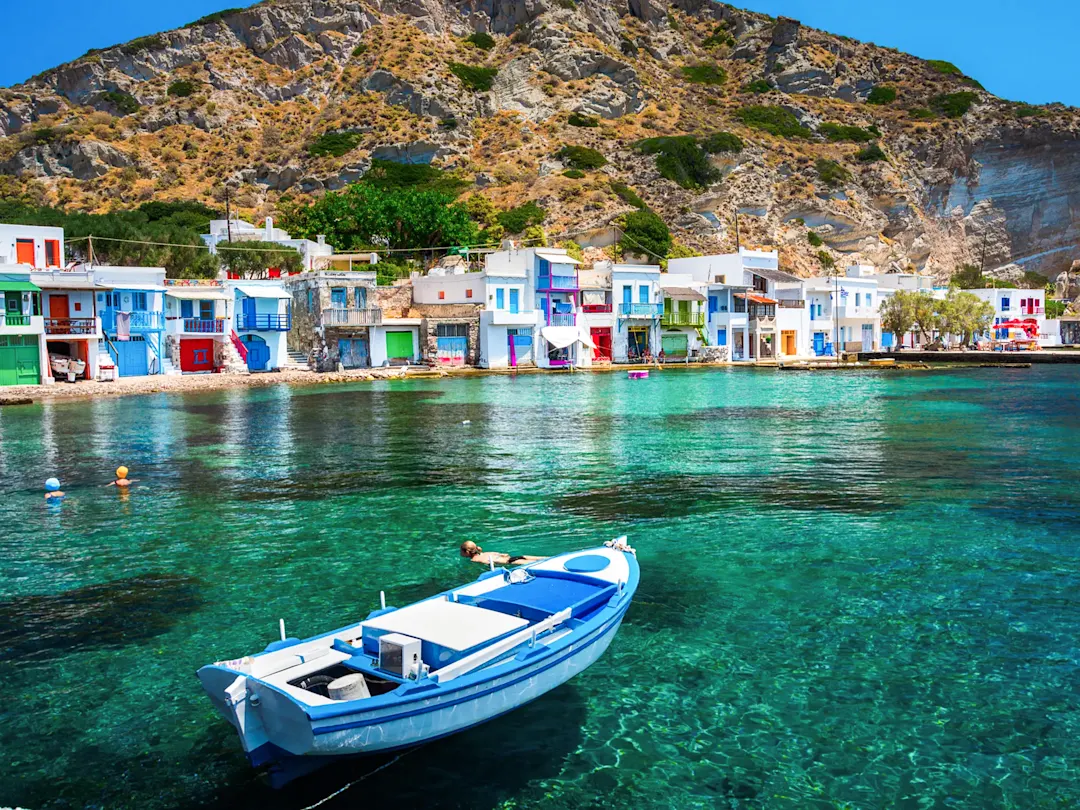 Bunte Fischerhäuser direkt am Meer mit ruhigem Wasser. Milos, Kykladen, Griechenland.
