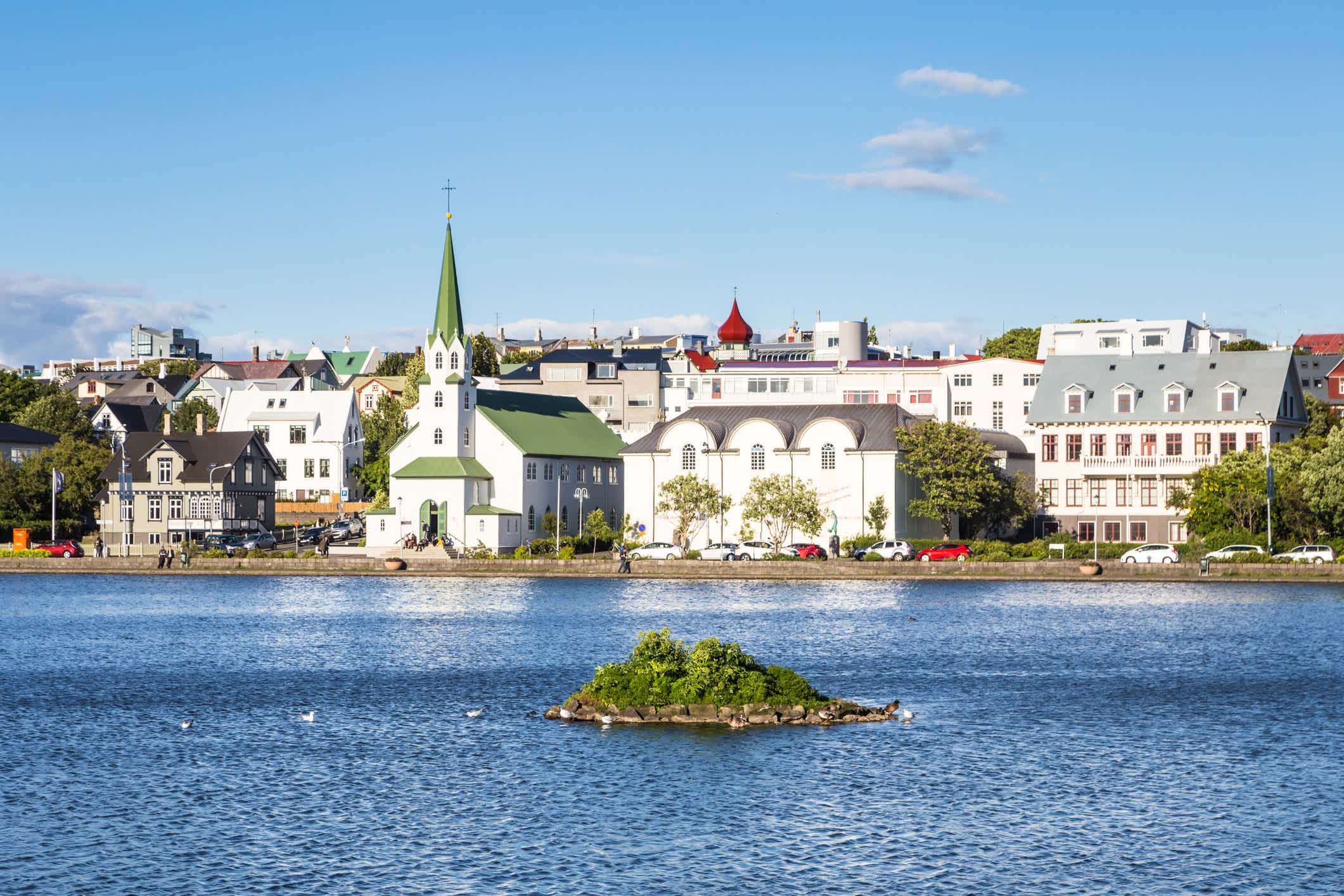 Reykjavík, the capital city of Iceland on a sunny summer day. Cityscape viewed from across the Tjornin lake.