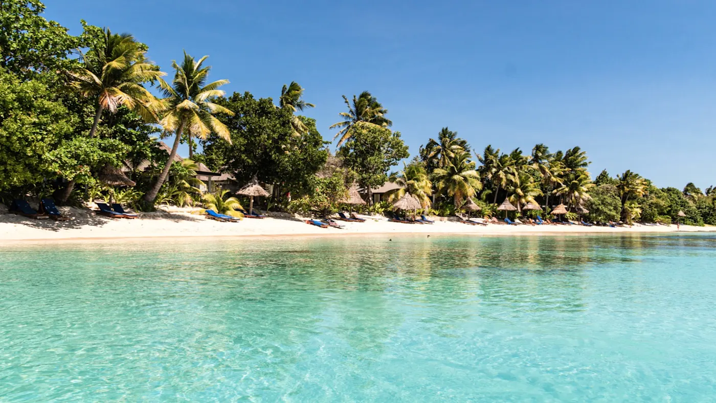 Yasawa-Inseln, Strand, Fidschi Strand mit Palmen und kristallklarem Wasser unter blauem Himmel. Yasawa-Inseln, Westliche Division, Fidschi.