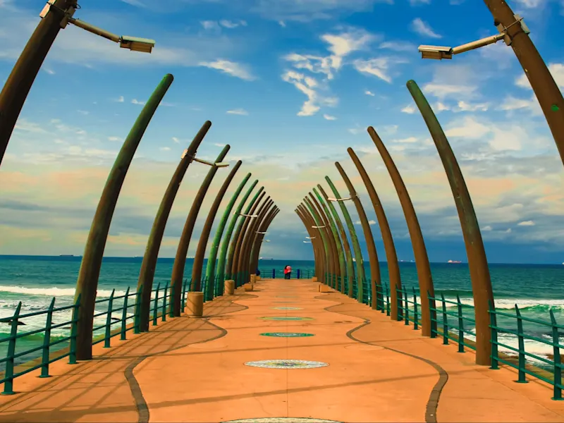 Umhlanga, KwaZulu-Natal, Südafrika Blick entlang eines modernen Piers mit gebogenen Lampen am Meer. Umhlanga, KwaZulu-Natal, Südafrika.