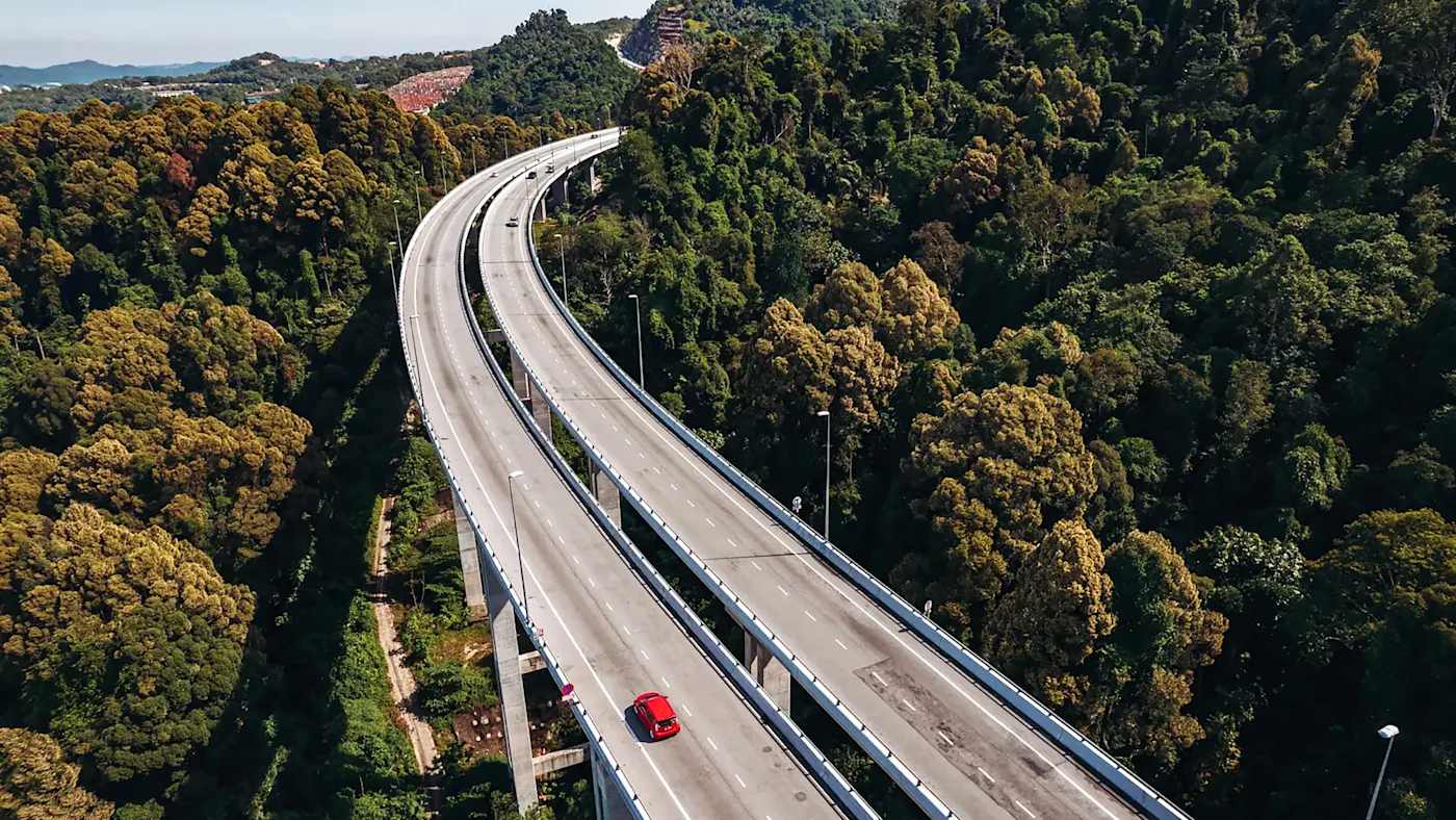 Malaysia, Road Trip Autobahn unter blühenden Bäumen. Malaysia.