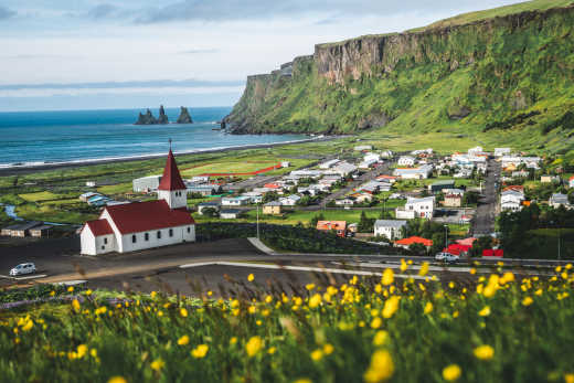Ville pittoresque au bord de la mer au sud de l'Islande avec une belle église et un paysagae verdoyant