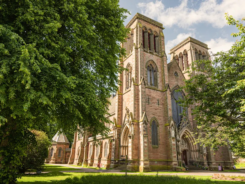 Inverness, Schottland, Vereinigtes Königreich Nahaufnahme der neugotischen St. Andrew's Cathedral umgeben von Bäumen. Inverness, Schottland, Vereinigtes Königreich.
