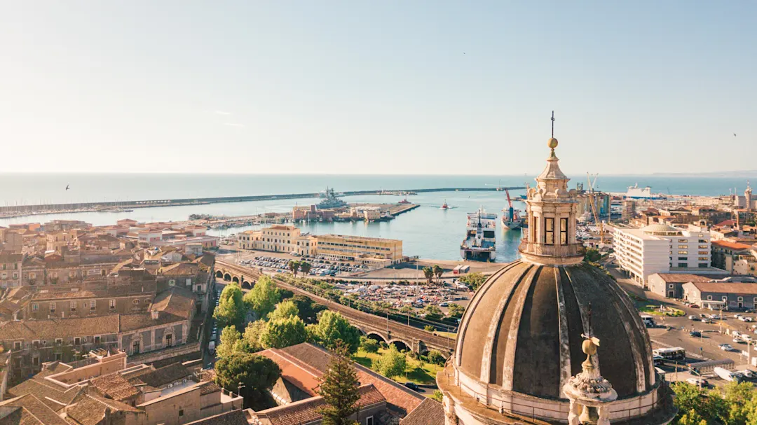 Blick auf den Hafen von Catania mit einer Kuppel im Vordergrund, Catania, Sizilien, Italien.
