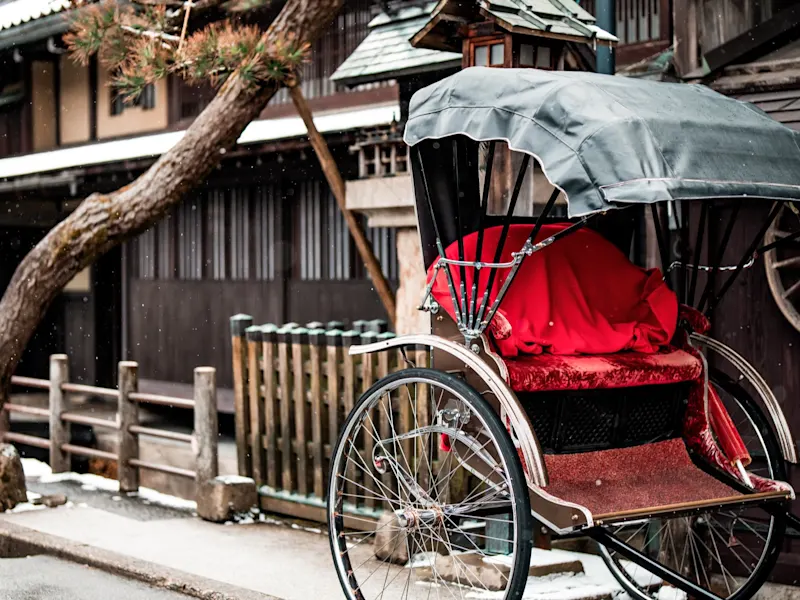 Takayama, Gifu, Japan Eine traditionelle Rikscha vor historischen Holzhäusern im Winter. Takayama, Gifu, Japan.