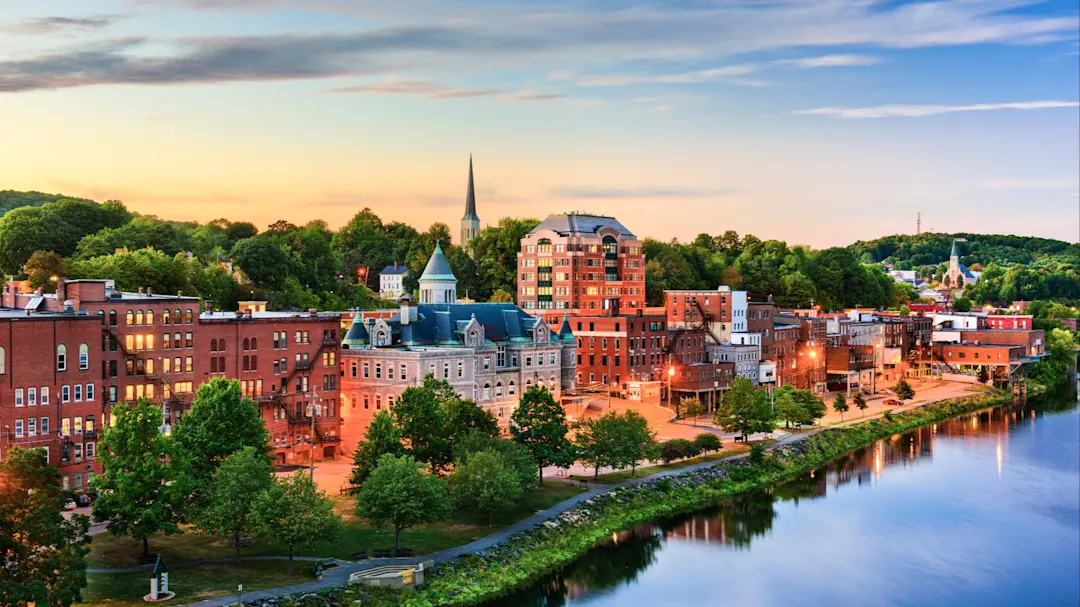 Historische Innenstadt mit Flussufer und grünen Bäumen bei Sonnenuntergang. Portland, Maine, USA.