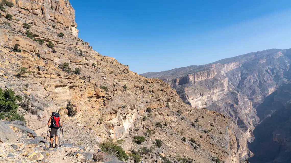 Randonneurs au bord du Grand Canyon/Wadi Nakha au coucher du soleil, Oman.