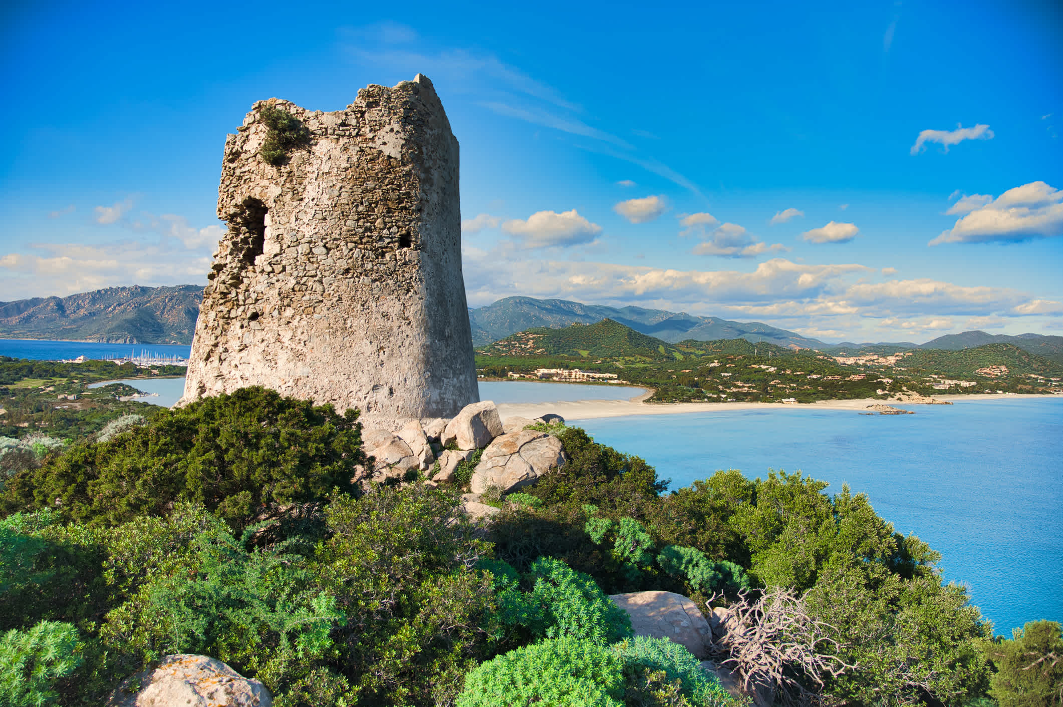 Alter Wachturm auf einem Hügel mit Meer im Hintergrund auf Sardinien.