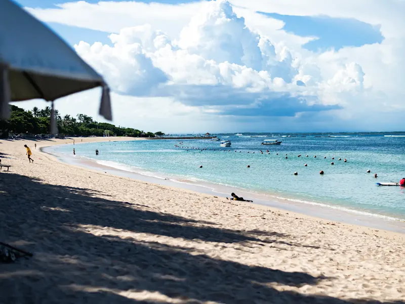 Indonesien, Bali, Nusa Dua Ruhiger Sandstrand mit klarem Wasser und Booten. Nusa Dua, Bali, Indonesien.