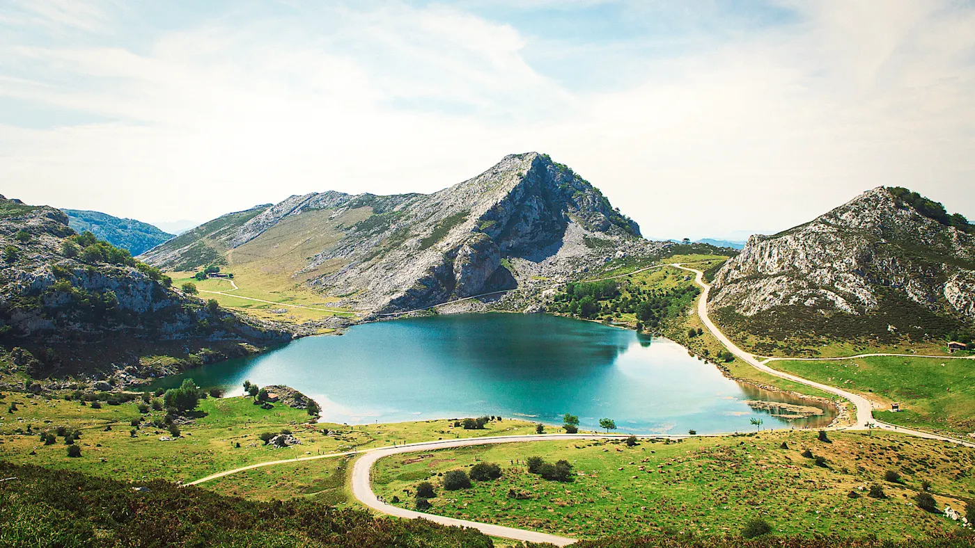 Spanien, Asturien Idyllischer Bergsee umgeben von grünen Wiesen und felsigen Bergen, Asturien, Spanien