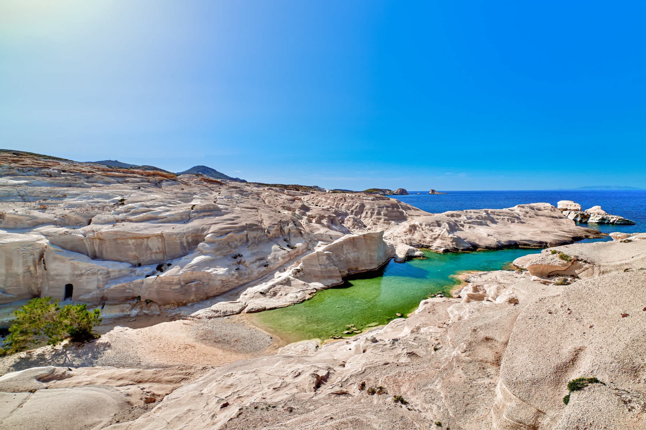 Schöne Landschaft mit weißen Felsen am Strand von Sarakiniko, Ägäis, Insel Milos, Griechenland. Leere Klippen, Sommersonne, klares Meerwasser, azurblaue Lagune