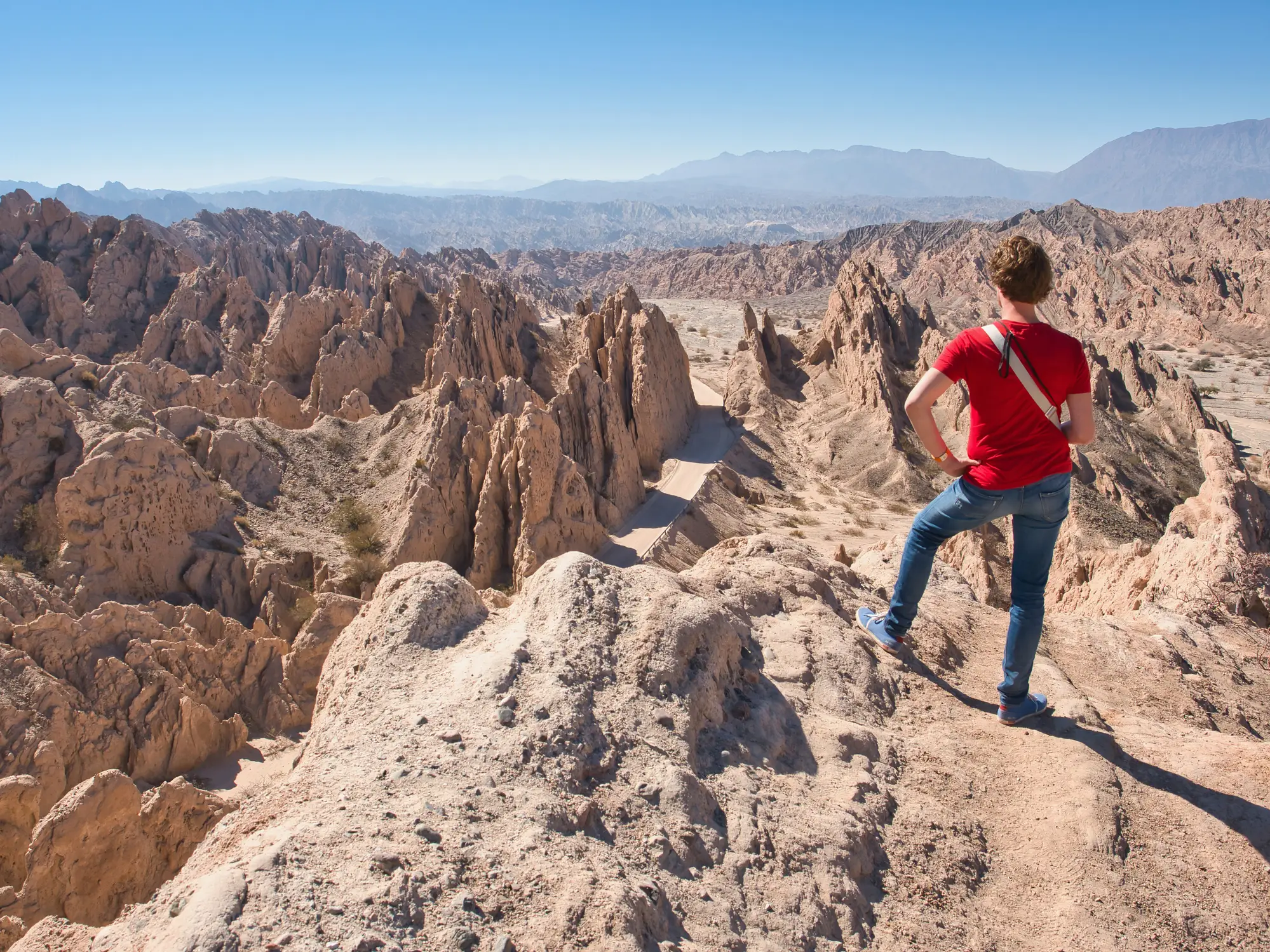 Argentinien, Cachi, Quebrada de las Flechas Ein Mann beobachtet die surreale Landschaft von Quebrada de las Flechas zwischen Cafayate und Cachi in Argentinien.