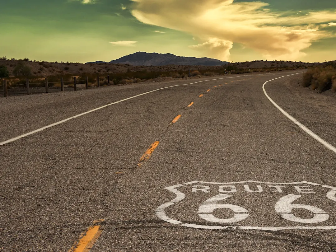 Legendäre Route 66 durch die Wüste bei Sonnenuntergang. Amboy, Kalifornien, USA.
