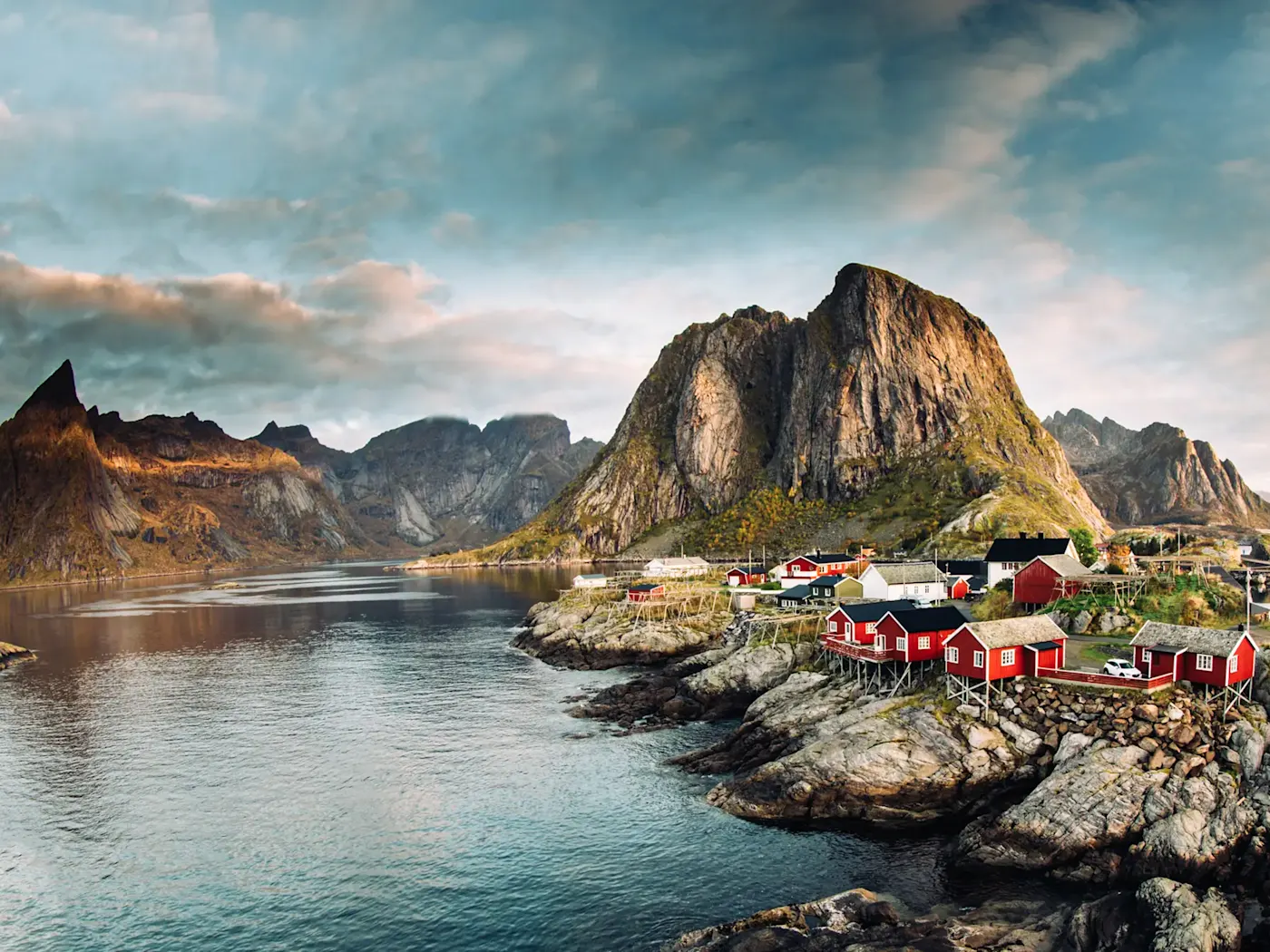 Rote Fischerhütten vor dramatischen Bergen und Fjordlandschaft. Hamnøy, Nordland, Norwegen.