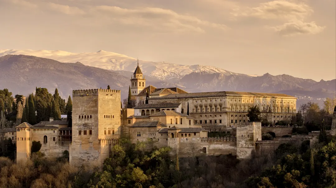 Panoramablick auf die Alhambra vor der Sierra Nevada bei Sonnenuntergang. Granada, Andalusien, Spanien.