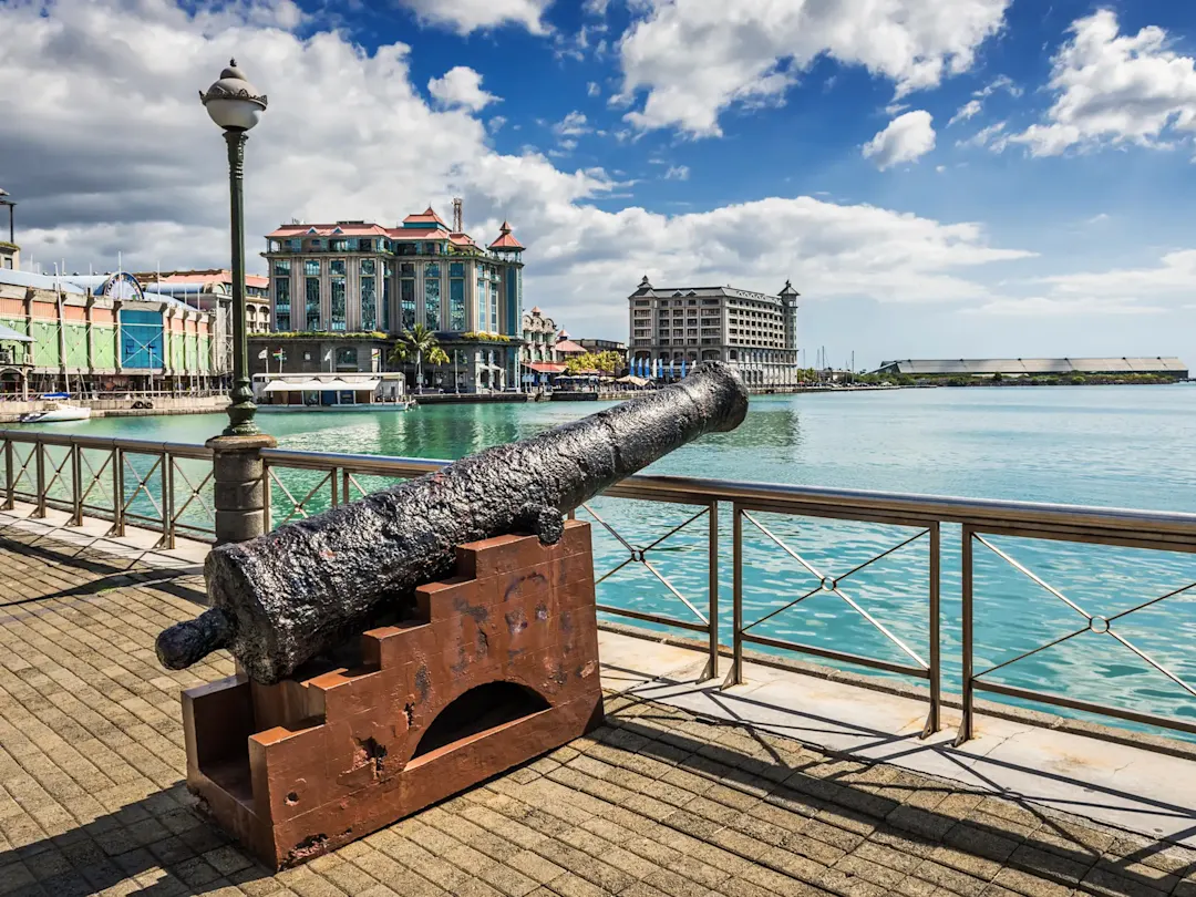 Mauritius, Port Louis Historisches Kanonenrohr mit Blick auf die Uferpromenade von Port Louis, Mauritius.