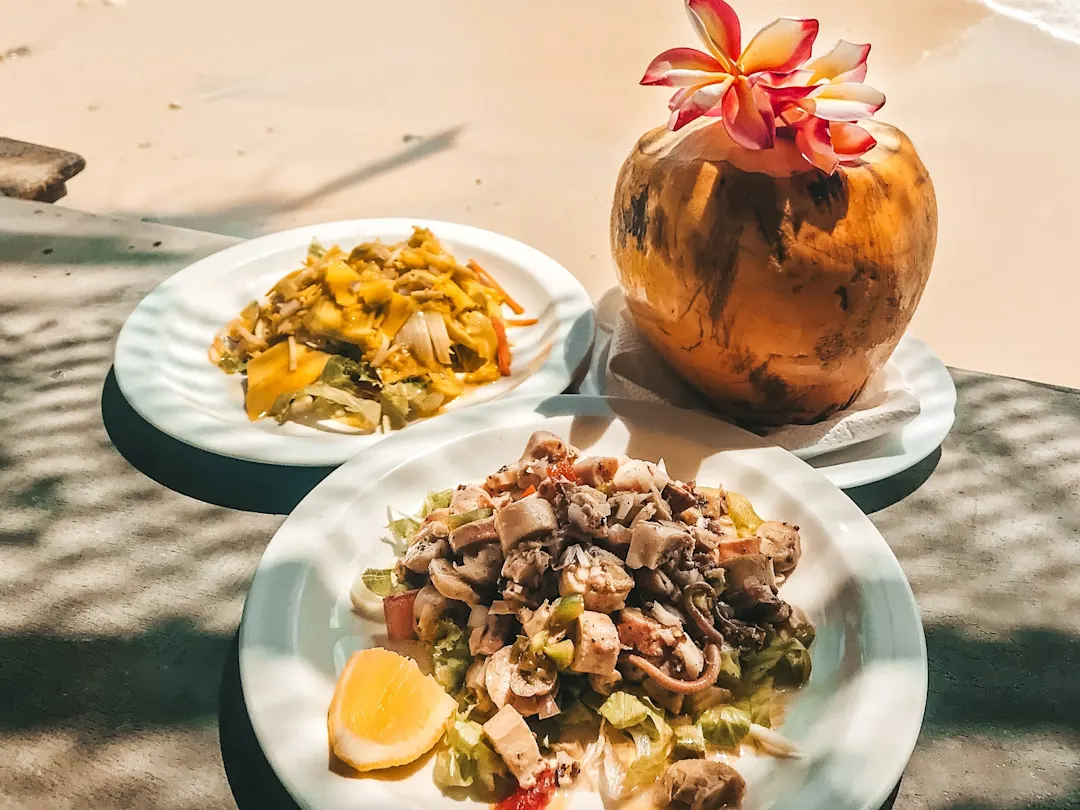 typische Gerichte der Seychellen mit einer Kokosnuss am Strand