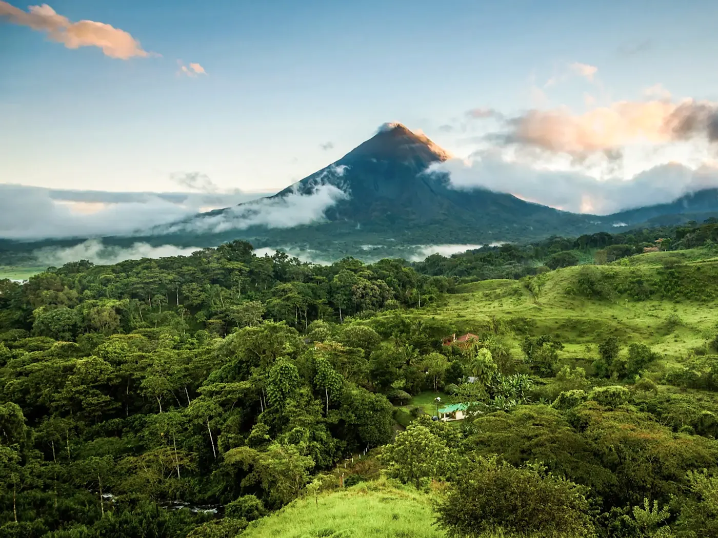 Vulkan Arenal im Nebel, von grünen Hügeln umgeben, La Fortuna, Alajuela, Costa Rica.
