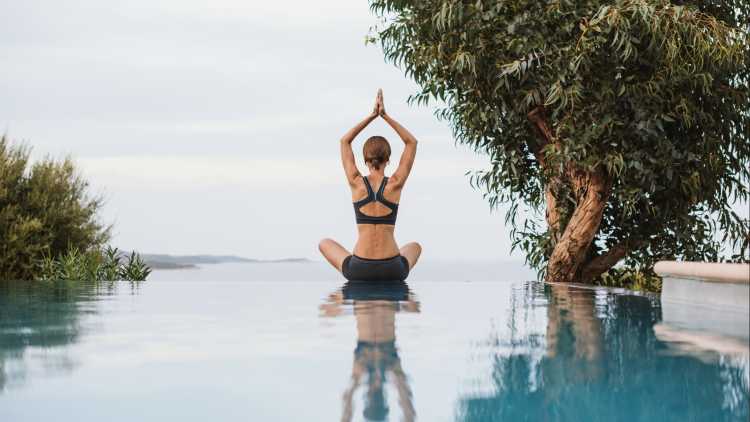 Junge Frau in Lotus Pose praktiziert Yoga