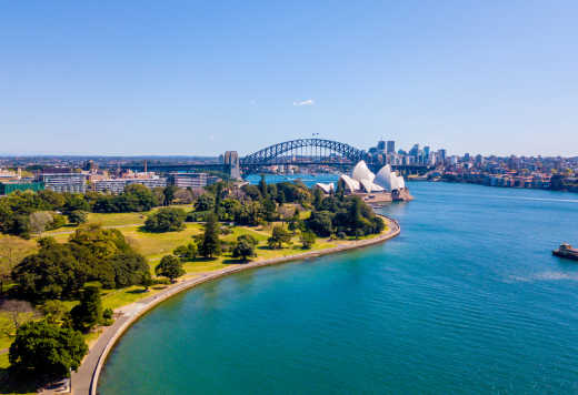Magnifique panorama sur le quartier du port de Sydney avec le Harbour bridge en fond, le jardin botanique et le bâtiment de l'Opéra. Trois incontournables à découvrir pendant votre voyage à Sydney.