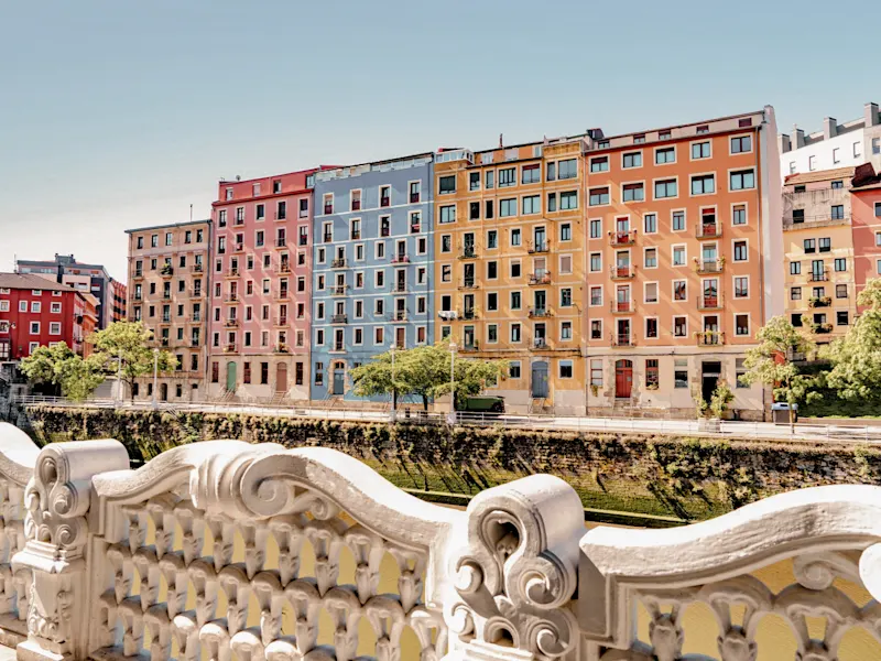 Bunte Häuserfassaden entlang des Nervión-Flusses bei Sonnenschein. Bilbao, Baskenland, Spanien.